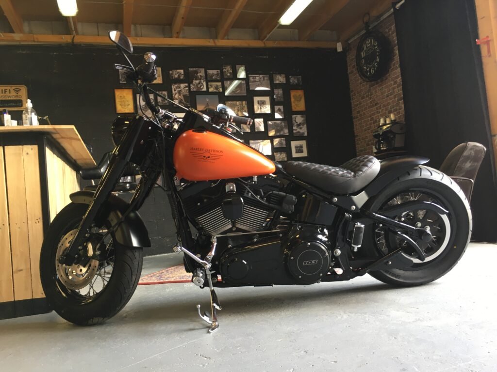 Harley-Davidson Softail Slim orange et noire après modification, dans l'espace d'accueil de l'atelier