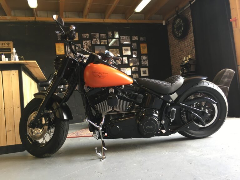 Harley-Davidson Softail Slim orange et noire après modification, dans l'espace d'accueil de l'atelier